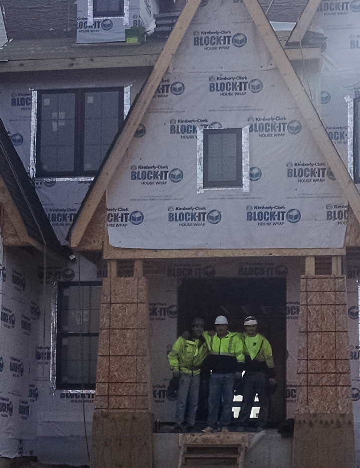Team standing in the entry way of a new home being built